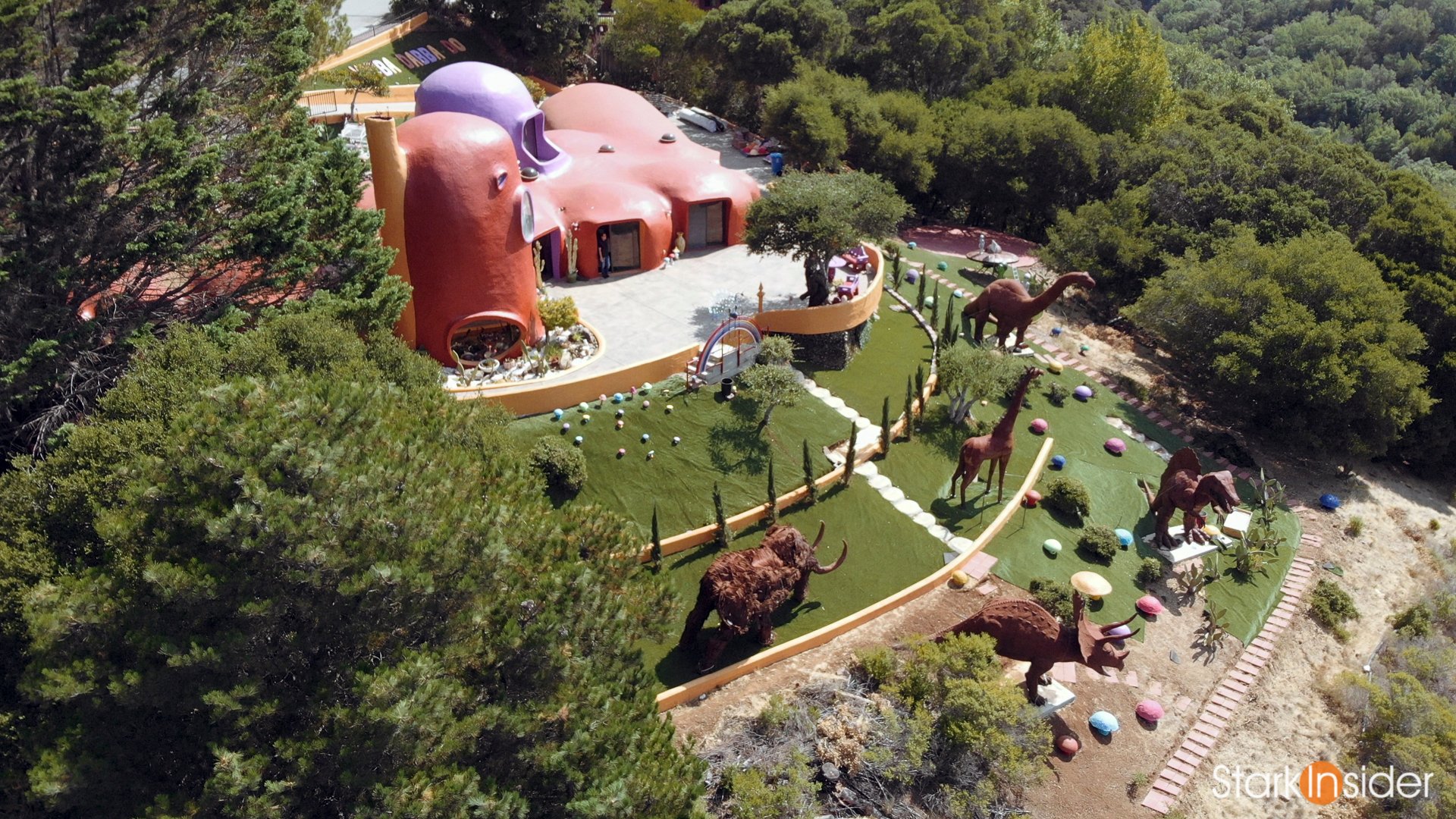 Aerial drone view of Flintstone House dinosaurs overlooking Highway 280 - Bay Area landmark